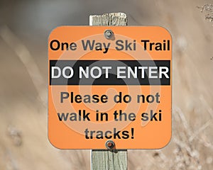 Sign saying Ã¢â¬Ëdo not enterÃ¢â¬â¢ - Ã¢â¬Ëone way ski trailÃ¢â¬â¢ - taken in late Winter on a sunny day